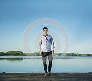 Handsome young man on a lake in a sunny, peaceful