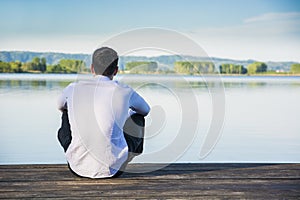 Handsome young man on a lake in a sunny, peaceful