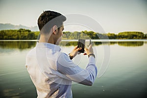 Handsome young man on a lake in a sunny, peaceful