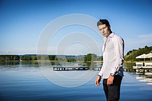 Handsome young man on lake in a sunny, peaceful