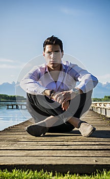 Handsome young man on lake in a sunny, peaceful