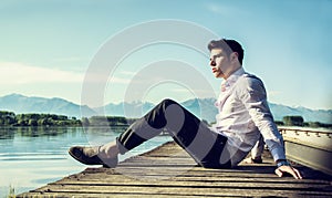 Handsome young man on lake in a sunny, peaceful