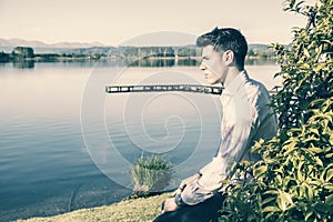 Handsome young man on a lake in sunny, peaceful