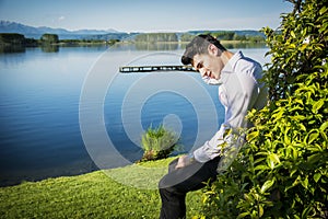 Handsome young man on a lake in sunny, peaceful