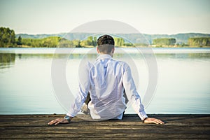 Handsome young man on lake in a sunny, peaceful