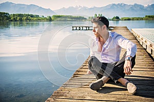 Handsome young man on a lake in a sunny, peaceful