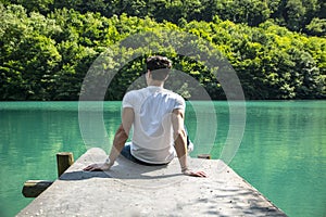 Handsome young man on a lake in a sunny, peaceful