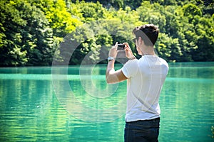 Handsome young man on a lake in a sunny, peaceful