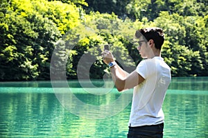 Handsome young man on a lake in a sunny, peaceful