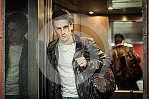 Handsome young man leaning against mirror in elevator or lift