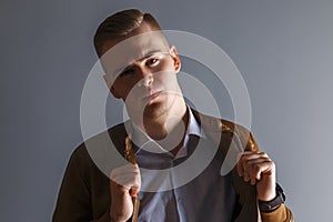 Handsome young man in leather jacket poses