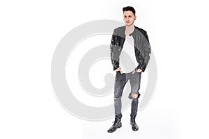 Handsome young man in leather jacket stand isolated in white background in a depressed and melancholic way while look to side and