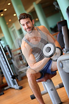 Handsome young man lifting weights