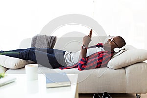 Handsome young man listening to music with headphones at home.