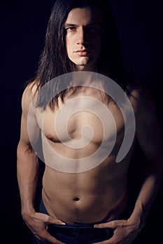 Handsome young man with long hair naked torso