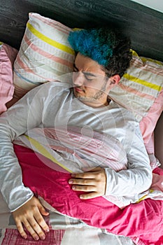 Handsome young man in long-sleeve pajamas having nightmares in his bed