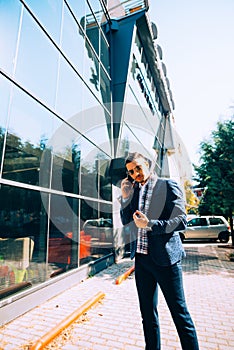 A handsome young man, looking good is having a phone conversation in the city center