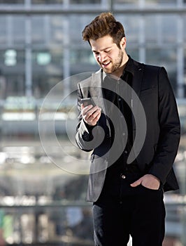 Handsome young man looking at mobile phone text message