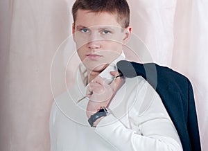 Handsome young man looking serious, holding jacket