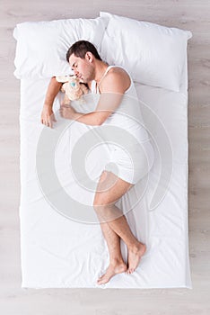 Handsome young man lying on bed