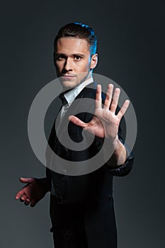 Handsome young man magician showing his palm