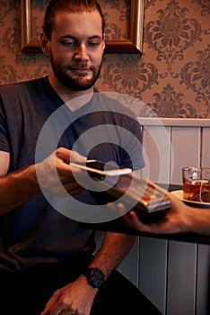 Handsome young man making electronic payment