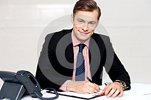 Handsome young man making notes