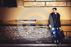 Handsome young man model on street grunge wall