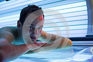 Handsome young man in a modern solarium