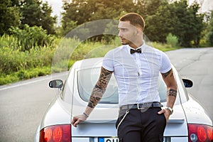 Handsome young man next to car in white shirt