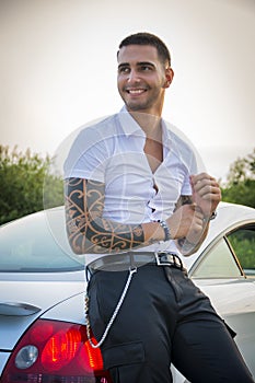 Handsome young man next to car in white shirt