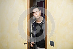 Handsome young man opening door to enter