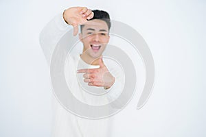Handsome young man over white isolated background smiling making frame with hands and fingers with happy face