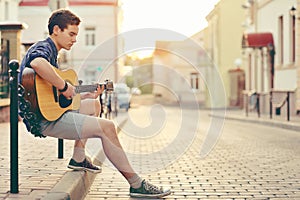 Handsome young man playing guitar