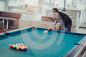 Young man playing pool in pub