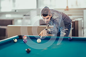 Young man playing pool in pub