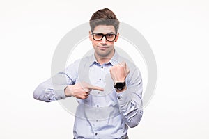 Handsome young man pointing at his smart watch isolated on white background