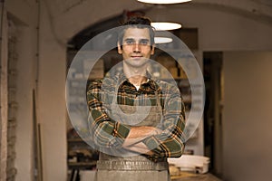 Handsome young man posing in pottery workshop