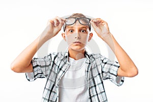 Handsome young man raises glasses on forehead in surprise, teen boy shocked, in Studio on white background