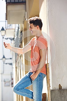 Handsome young man reading text message on cell phone