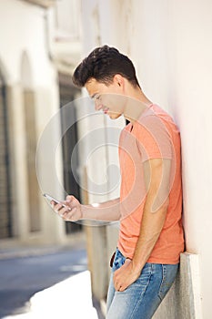 Handsome young man reading text on mobile phone