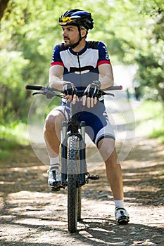 Handsome young man relaxing after cycling in the mountain.