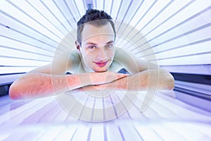 Handsome young man relaxing in a modern solarium