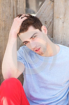 Handsome young man relaxing outdoors with hand in hair