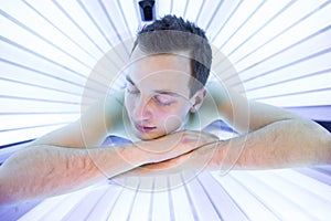 Handsome young man relaxing in a solarium