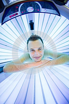 Handsome young man relaxing during a tanning session