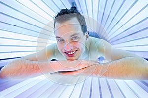 Handsome young man relaxing during a tanning session