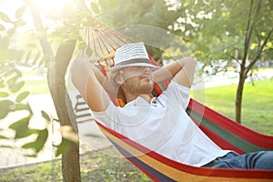 Handsome young man resting in hammock outdoors