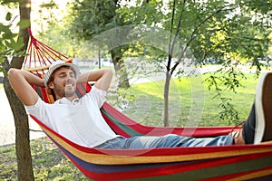 Handsome young man resting in hammock outdoors