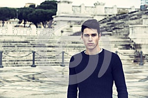 Handsome young man in Rome in front of Vittoriano monument